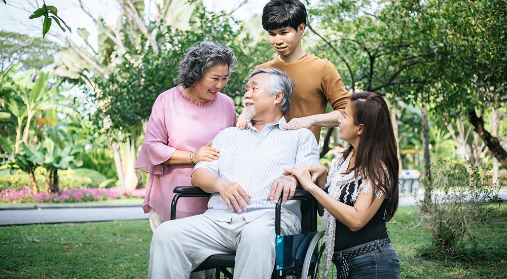 cheerful disabled grandfather in wheelchair welcoming his happy Family